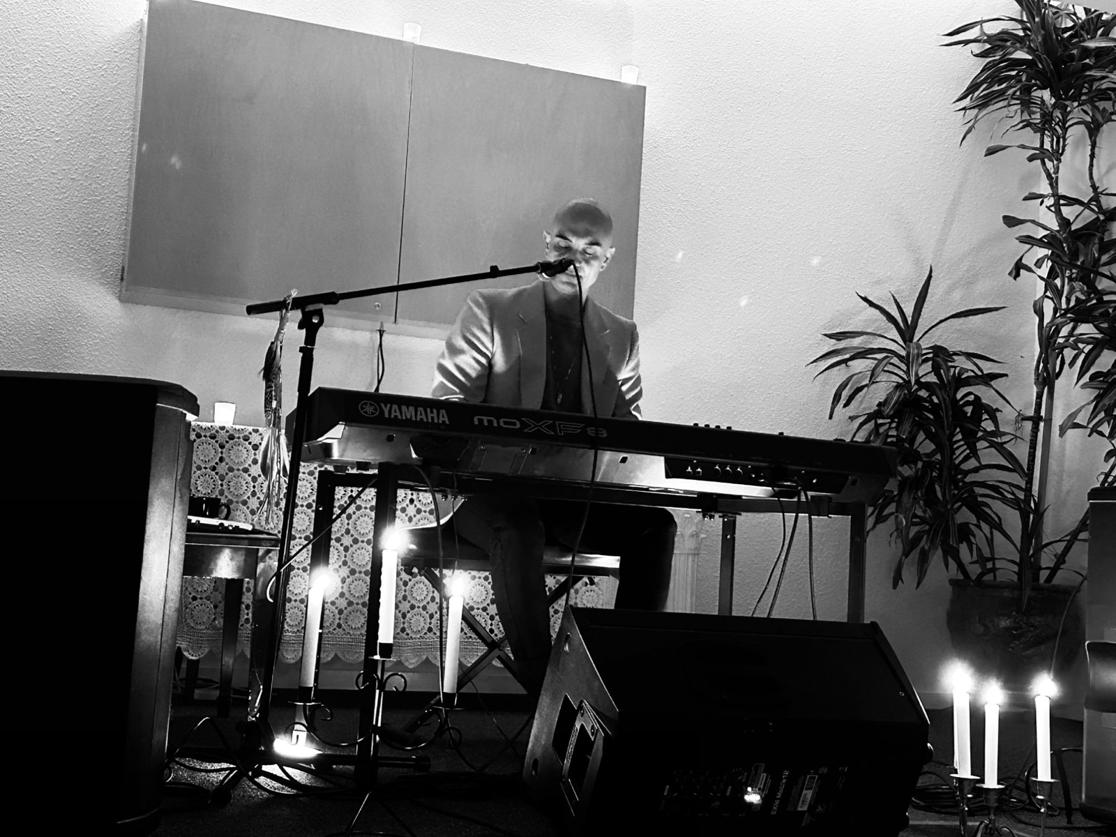 Julien Loreto singing and playing keys at a candlelit live show